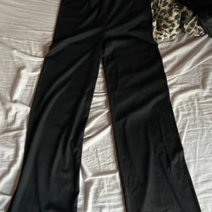 Svarta ribbade byxor från Bik Bok - Säljer ett par svarta ribbade byxor från Bik Bok. De är högmidjade och har en loose passform, vilket gör dem superbekväma för både vardag och fest. Perfekta för höst och vinter med en mysig tröja eller en snygg topp. Storleken är dam M.