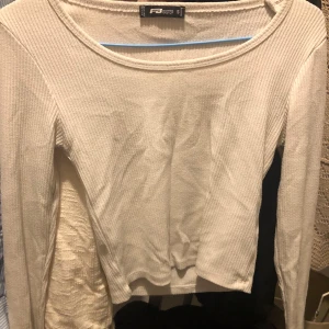 Vit ribbad tröja från FB Sister - Säljer en snygg vit ribbad tröja från FB Sister i storlek S. Den har en enkel och stilren design med långa ärmar och en bekväm passform. Perfekt för både vardag och fest! 🖤