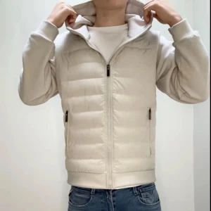 Viellas cardigan - Snygg vit cardigan med dragkedja och huva. Jackan har långa ärmar och två praktiska fickor med dragkedja. Perfekt för kyligare dagar.