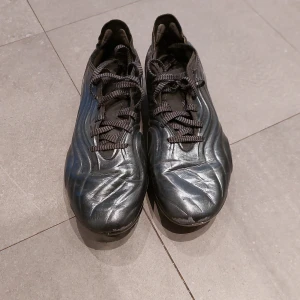 Silvriga fotbollskor. Adidas copa - Säljer ett par Silvriga Adidas copa i syntetmaterial. De har en cool vågig design och snörning för bra passform. Perfekta för fotbollsträning eller match. Skorna är i bra skick och redo för nya äventyr på planen! Nypris 3000kr