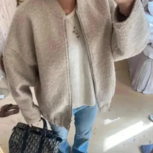 Beige teddyjacka - Mysig beige teddyjacka i oversized passform. Perfekt för höst och vinter med dragkedja framtill. Jackan är långärmad och gjord av ett mjukt, fluffigt material som håller dig varm och stilren. De första är Lånade bilder