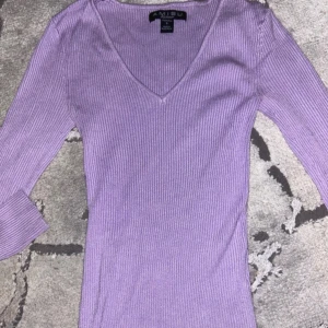 Lila ribbad topp  - Snygg lila ribbad topp med v-ringning. Använt fåtal gånger.