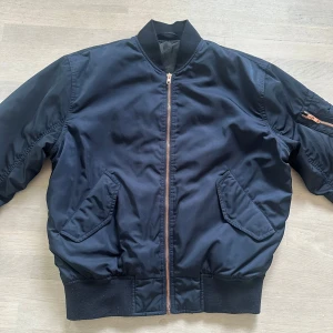 bomberjacka från Filippa K - Snygg och helt slutsåld bomberjacka från Filippa K med dragkedja och fickor fram. Jackan har en klassisk bomberstil med ribbade muddar och en liten ficka med dragkedja på ärmen. Perfekt för en stilren look. Väldigt dyr i inköp