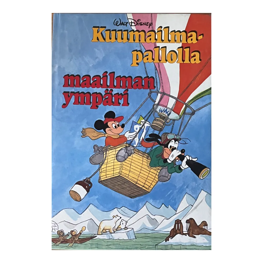 En bok med Musse Pigg och Långben på äventyr i en luftballong. Omslaget visar dem i en korg över snötäckta berg med en kikare. Boken är på finska och verkar vara en del av en serie med klassiska Disney-karaktärer.. Böcker.