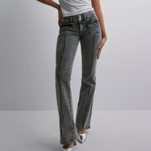 Grå bootcut jeans - Säljer mina as snygga lågmidjade jeans ifrån Nelly, skicket är fint förutom att de är pyttelite nertrampade längst ner. De är helt slutsålda, nypris: 700kr💞😇
