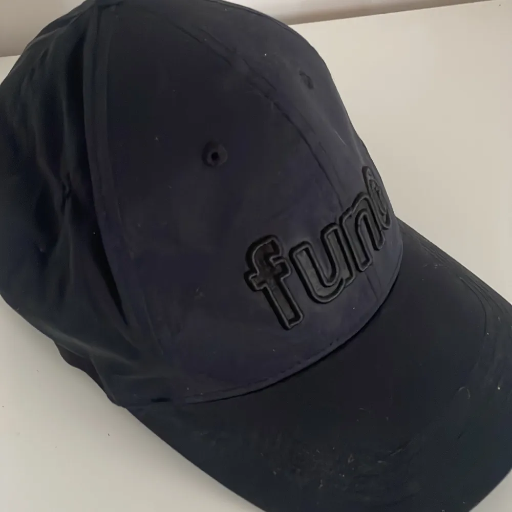 Säljer en svart keps från Func. Den har en broderad logga framtill och justerbart spänne bak. Perfekt för vardagsbruk eller träning. Kepsen är i bra skick och passar de flesta tack vare den justerbara passformen.. Asusteet.