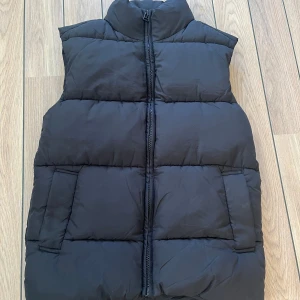 Svart oversized pufferväst - Västen är näst intill oanvänd, bara använt ett fåtal gånger. Den är i storlek XXS. Men då den är väldigt oversized skulle jag säga att den passar till personer med storlek XS och även S