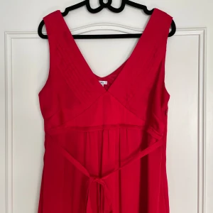 Röd klänning  - Supervacker röd klänning som går att knyta både fram och bak. I bra skick! I storlek 46 men funkar även bra på mig som har xs. 