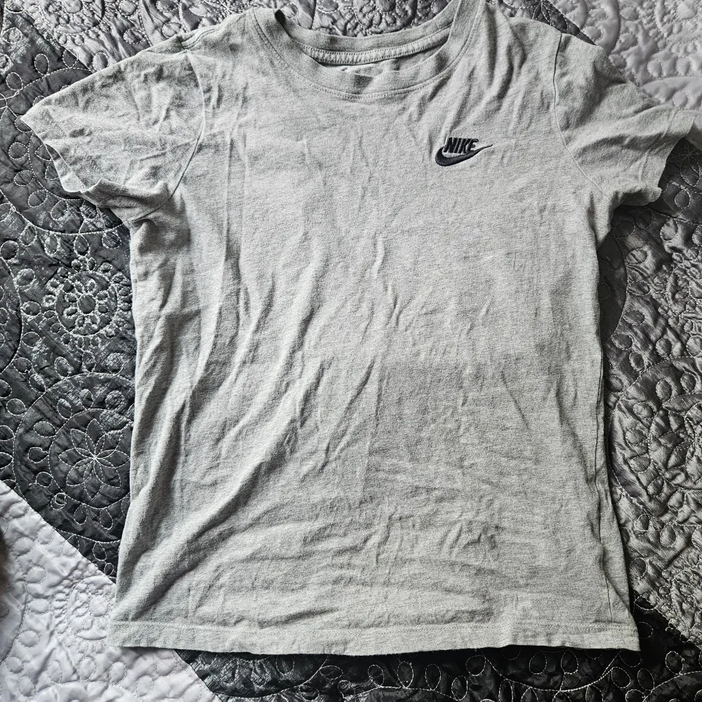 Säljer en grå t-shirt från Nike i storlek XS/S. Den är kortärmad och har en klassisk Nike-logga på bröstet. Perfekt för vardagsbruk eller träning. T-shirten är i bomull och känns skön mot huden.. T-shirts.