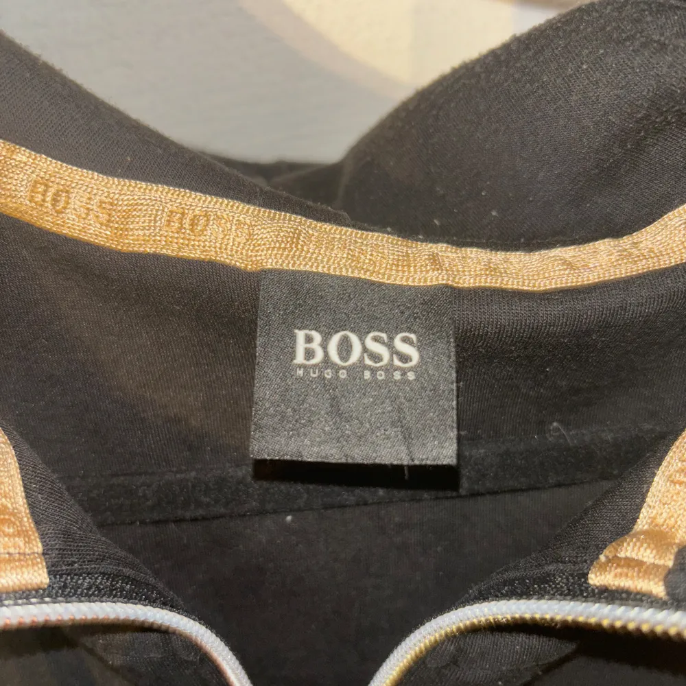 Hugo boss hoodie med guldiga detaljer, har lite knotter men annars bra skick, inga hål eller andra skador, knotter går att få bort Storlek L men passar även M. Tröjor & Koftor.