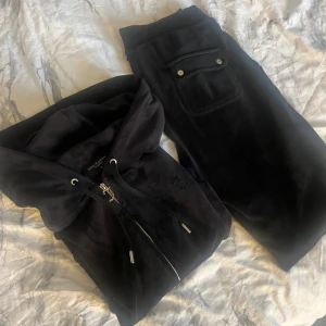 Juicy couture - Säljer mitt svarta Juicy Couture sätt då det inte kommer till användning, så sparsamt använt. Tröjan är i storlek M, men upplever den mer som en S. Byxorna är i storlek S.  Kan säljas var för sig för 500kr styck, inkl frakt!