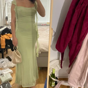 Grön klänning  - Använd en gång, en mesh klänning med hängande ruffles.