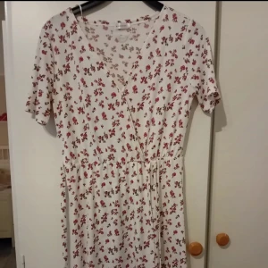 V-ringad vit och rosablommig klänning  - Använd fåtal gånger  Storlek M