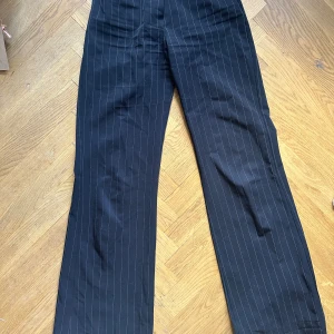 Svarta kostymbyxor  - Lågmidjade kostymbyxor med vida ben