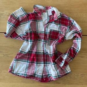 Rutig skjorta från H&M - Säljer pjyamaströja från H&M i storlek S. Skjortan har knappar framtill och en bröstficka. 100% bomull, super skön och använd max 5 gånger. en extra knapp medföljer🫶