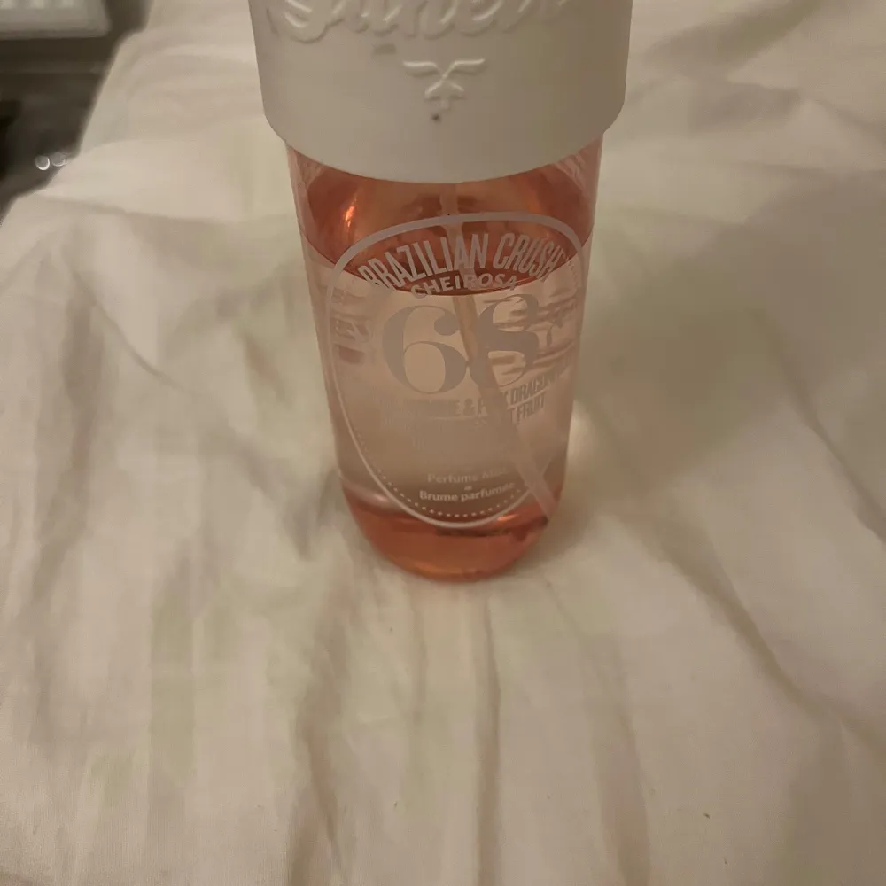 En doftspray med noter av brasiliansk jasmin och drakfrukt. Flaskan är rosa med en vit kork och rymmer 240 ml. Perfekt för att ge en fräsch och exotisk känsla.. Perfume.