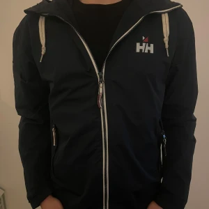 Helly Hansen jacka  - Säljer en riktigt snygg vindjacka från helly Hansen i bra skick. Storleken är S, tveka inte att höra av er vid frågor och funderingar. Priset kan diskuteras vid snabb affär🫡🍾