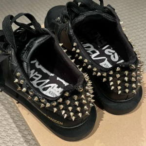 Svarta sneakers med nitar från Steve Madden - Snygga svarta sneakers från Steve Madden med coola nitar på hälen och sidan. Skorna har snörning och en robust sula. Perfekta för att ge din outfit en edgy touch. Knappt använda 