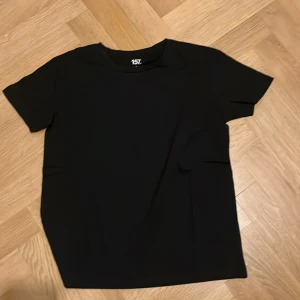 Svart t-shirt  - En klassisk svart t-shirt . Perfekt basplagg med rund hals och korta ärmar. Enkel och stilren design som passar till det mesta.
