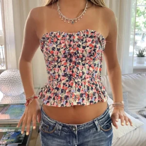 Blommig tubtopp!!💖💖😍 - Säljer en söt blommig tubtopp med volangdetaljer. Toppen har en färgglad design med rosa, blå och vita blommor. Den är i storlek 42 men skulle säga att den passar som en M men även mot S!! 💖💖☺️sååå najsss