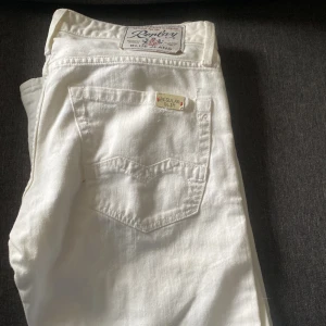 Vita jeans från Replay - Snygga vita jeans från Replay med knappgylf och klassisk femficksdesign. Perfekta för en stilren look. Märkesdetaljer syns på baksidan och insidan av midjan. Slitningar köpta för 1790 pris kan diskuteras 