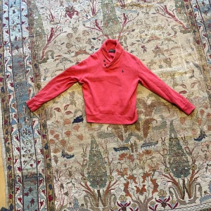 Röd cardigan från Ralph Lauren - Säljer en snygg röd tröja från Ralph Lauren med en shawl krage med två knappar.  Solblekt färg men utöver det bra skick 👍