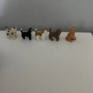 Schleich kattungar  - En samling av fem små kattfigurer i olika färger. Figurerna är i svart, vitt, brunt och orange.Perfekt för kattälskare eller som dekoration.