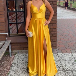 Festklänning  - En gul maxiklänning i satin, perfekt för bröllop eller bal. Har band som korsar i ryggen, superfin detalj! Den är i 34 men passar lika bra som 32 eftersom den är skräddarsydd. Använd en gång, den är kemtvättad💕pris kan diskuteras 