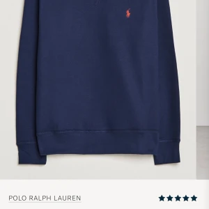 Mörkblå tröja från Polo Ralph Lauren - Säljer en stilren mörkblå tröja från Polo Ralph Lauren med det klassiska logotypbroderiet i orange på bröstet. Tröjan har rund hals och långa ärmar, perfekt för en avslappnad look.