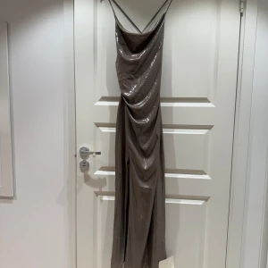 Adoore - Metallic Satin maxidress - Snygg metallic långklänning i satin från Adoore. ✨Aldrig använd och lappar finns kvar. Storlek S, justerbara band i ryggen och snygg slits i sidan. 
