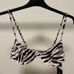 Zebramönstrad bikiniöverdel - Säljer denna helt nya bikiniöverdelen från NAKD då den var för liten för mig. Den är i storlek 70C (som jag vanligtvis har), men kupa B är en mer realistisk storlek. Bara att skriva om fler bilder önskas💕