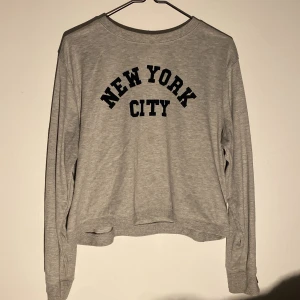 grå sweatshirt med New York City-tryck - här säljer jag en grå sweatshirt med texten 'New York City' i svart på framsidan. tröjan passar perfekt för en med size XXS-XS-S-M! tröjan ska vara lite 'baggy' så är perfekt för en 'casual look' men samt också en bra myströja! PS: helt ren med inga fettfläckar eller fläckar alls, har använt runt 2-3 gånger.