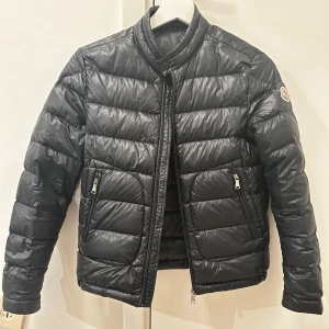 Äkta Moncler Jacka - En superfin moncler jacka perfekt nu till hösten❤️ Den är i strl 12 år, och är bara lite för kort för mig som e 170❤️Den har en lagning (bild 3) som knappt märks, och dragkedjan är lite krånglig (bild 4) men går nog att fixa❤️ Skriv för mer info❤️❤️
