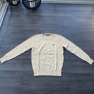 Beige stickad Ralph Lauren Sweater (helt ny) - Säljer denna ljusbeiga Ralph lauren tröjan i som oxå är i  skick! Nypris på Ralph laurens hemsida för denna (senaste modellen & stickad) är över 2000, mitt pris typ 500. Storlek M 