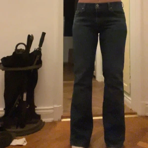 Low bootcut jeans Tommy Hilfiger - Lågmidjade mörkblåa utsvängda jeans från Tommy Hilfiger.  Storlek 8 vilket motsvarar 36/38. Är 165 som referens!! (Står på tå i bilderna för att få med hela jeansen på bild) så om du är något längre än mig så kommer det fortfarande vara långa🩷