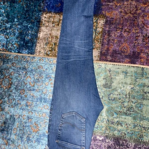 Blå jeans från Broadway - Säljer ett par snygga blå jeans från Broadway. De har en klassisk femficksdesign och en bekväm passform. Jeansen är i bra skick och har en lätt tvättad look som ger dem en cool stil. Perfekta för både vardag och fest!