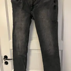 Säljer ett par grå jeans i slim fit med en snygg tvättad look. De har klassiska fem fickor och en knappgylf. Jeansen är i storlek W31 och är använda cirka 2 gånger 