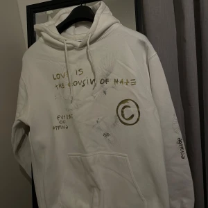 Vintage hoodie med unika detaljer och boxy passform - En otroligt snygg och unik vit vintage hoodie i storlek M med guldig samt grå text och mönster som får den att se tidlös ut! En hoodie i utmärkt skick som alltid får komplimanger, funkar även som unisex! Se passform samt hur den ser ut med outfits på de två sista bilderna! 👍