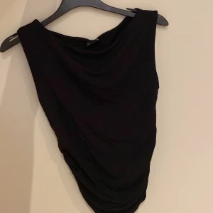 Svart topp från Gina Tricot - Säljer en stilren svart topp från Gina Tricot i storlek S. Toppen är ärmlös och har en enkel design som passar perfekt till både vardag och fest. Materialet känns mjukt och bekvämt mot huden. Perfekt att matcha med jeans eller en kjol för en chic look! ( Jag har klippt av lappen men toppen är inte använd)💕