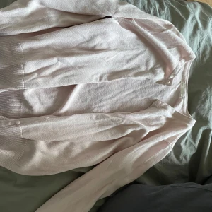 Ljusrosa kofta - Säljer en söt ljusrosa kofta i bra skick. Den har långa ärmar och knappar framtill. Kommer från H&M, storlek xs