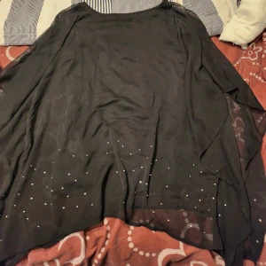 Blus - Fin svart blus med glitter nertill, fin att ha vid tex jul/ nyår. Medium