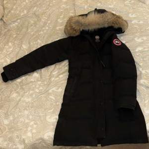 Super fin vinterjacka från Canada Goose I XS. Knappt använd med bara en liten fläck på ena ärmen, som garanterat går bort vid kemtvätt (skriv för bild).  Jackan är lite blekt  (syns på bilden).  Nypris 16.000-20.000kr. Bara använd en vinter 2021 så den är helt i nyskick. Äkthetsbevis i jackan finns med.