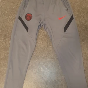 Nike x Psg tracksuit byxor  - Hej säljer ett par Psg byxor från nike pågrund av att dom är för stora. Byxorna säljs så billigt pågrund av att det finns en liten defekt på bild 5 att kedjan är lite sönder men kan fixas. Storlek M men passar S pris kan diskuteras. Skriv vid minsta fundering och skriv innan köp⚡️🍾🍾