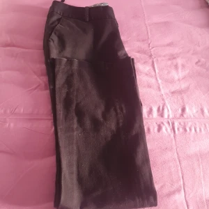 Svarta byxor - Säljer ett par svarta byxor i bra skick. De har en klassisk stil med raka ben och knappar bak. Perfekta för både vardag och fest. Passar till det mesta i garderoben! Saknas dock två knappar.