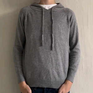 Grå merinoull hoodie - Säljer nu denna sköna merinoull hoodie i storlek xs. Personen på bilden är 162cm lång för referens. Inga defekter eller liknande.Den har en sjusterbar luva och är supervarm, perfekt nu till vintern.om du undrar något tveka inte med att fråga. pris kan diskuteras. 