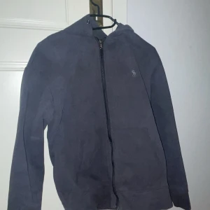 Zip hoodie från Polo Ralph Lauren - Säljer en snygg mörkgrå hoodie från Polo Ralph Lauren i storlek S. Den har en dragkedja framtill och är långärmad, perfekt för höst och vår. Den är i bra skick och har en liten broderad logga på bröstet. Superbekväm och stilren! Använd fåtal gånger