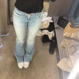 Ljusblå bootcut jeans - TAR INGA PRISFÖRSLAG❌❌Säljer ett par ljusblå bootcut jeans i bra skick, säljer då dom är för små. De har snygga slitningar på knäna och en klassisk femficksdesign. Dom är använd fåtal gånger. Syns inte att dom är använda. Storlek 34. Skriv om du vill ha mer bilder.💕