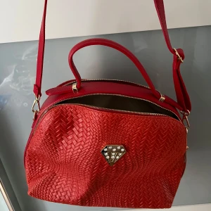 Brun handväska från RLL - Snygg brun handväska från RLL i skinn med stilrena detaljer. Väskan har en dragkedja upptill och en elegant tagg som hänger på sidan. Perfekt för både vardag och fest!