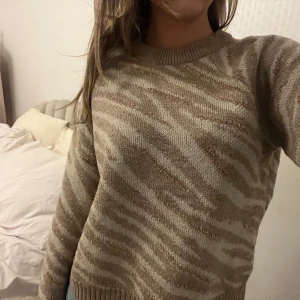 Beige och brun tröja från ONLY - Säljer en superfin beige och brun tröja från ONLY med zebramönster. Den är stickad och har långa ärmar, perfekt för höst och vinter. Tröjan är i bra skick och passar perfekt för en mysig dag hemma eller en promenad i parken.