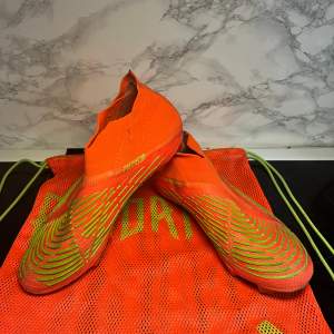 Säljer ett par grymma Adidas Predator fotbollsskor i en cool orange och grön färgkombination. Skorna är i syntetmaterial och har en tight passform för bästa bollkontroll. Perfekta för fotbollsspelare som vill sticka ut på planen. Använda men i bra skick! (Priset kan diskuteras!)